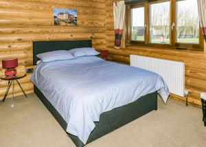 a bedroom with a bed in a log cabin at Laxfield Lodges in Laxfield +11 photos
