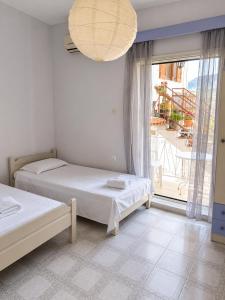a bedroom with two beds and a large window at Galatas home in Galatas