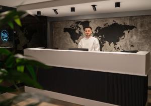 a man standing behind a counter with a map on the wall at Eylül Homes in Trabzon