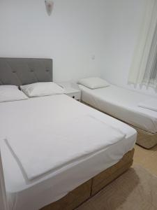 two beds sitting next to each other in a room at Elite Apart Pansiyon in Gokceada Town