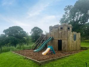 a wooden playground with a slide in a yard at Pinhaw Beacon - Ukc9595 in Earby