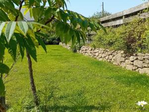 a garden with a green lawn and a stone wall at The Barn in Helston