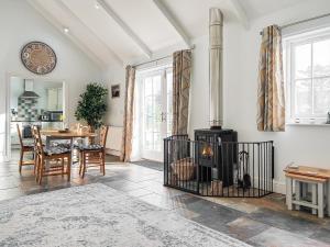 a living room with a fireplace and a table at The Barn in Helston