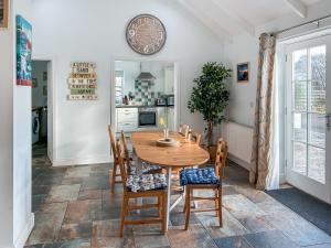 a dining room with a wooden table and chairs at The Barn in Helston
