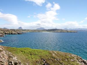 a large body of water with mountains in the background at Thistle Cottage - Uk5867 in Achmelvich