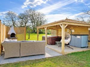 a wooden gazebo with a grill and a grill at Egmont Farmhouse in Newenden