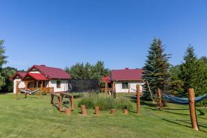 a playground with a house and a hammock in a yard at Leśna Oaza in Sasino