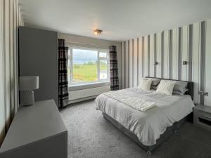a bedroom with a large bed and a window at Poplar Zareba in Anderby