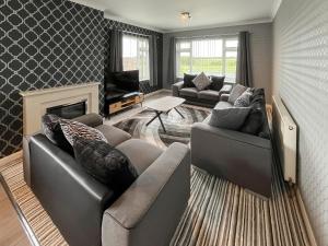a living room with two couches and a fireplace at Poplar Zareba in Anderby