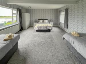 a bedroom with two beds and a large window at Poplar Zareba in Anderby +5 photos