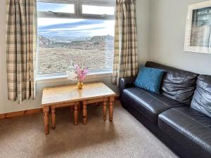 a living room with a couch and a coffee table at Orchid Cottage - Uk5866 in Achmelvich