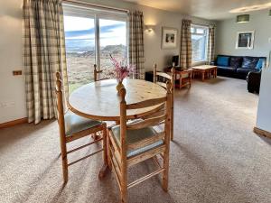 a living room with a table and chairs and a couch at Orchid Cottage - Uk5866 in Achmelvich