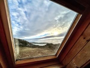 a window in a room with a view of the ocean at Orchid Cottage - Uk5866 in Achmelvich