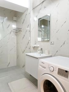 a white bathroom with a washing machine and a mirror at Arthouse Elbasan in Elbasan +43 photos