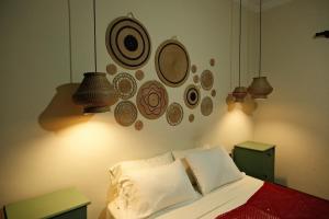 a bedroom with a bed with plates on the wall at Hotel Pata y Perro in Tarija