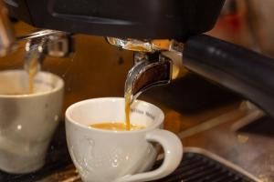 a coffee maker pouring coffee into a coffee cup at Hotel Mozart in Landeck