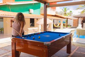a woman playing billiards in a pool table at Pousada Residência Lençóis in Barreirinhas