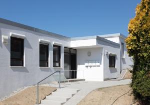 a white building with stairs in front of it at Apartment Lichterfunkeln für junge Paare mit Panorama-Seeblick in Daisendorf +6 photos