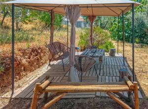 a wooden deck with a table and chairs under an umbrella at Casa das Romãs in Salvada