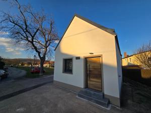 a small white building with a door on a street at Wiegehaus Retz in Retz