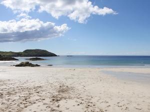 a beach with footprints in the sand and the ocean at Fern Cottage - Uk5868 in Achmelvich +7 photos