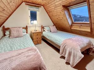 two beds in a room with two windows at Fern Cottage - Uk5868 in Achmelvich