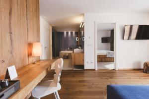 ein Zimmer mit Schreibtisch und ein Schlafzimmer mit Bett in der Unterkunft Hotel Hohenwart in Schenna