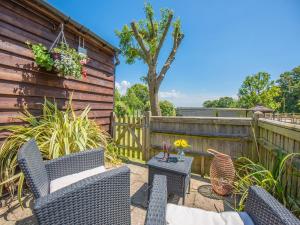 a patio with chairs and a table and a fence at The Lodge in Northiam