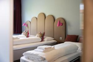 Eine Reihe Betten in einem Zimmer mit weißen Laken in der Unterkunft Bunks at Rode in Oslo