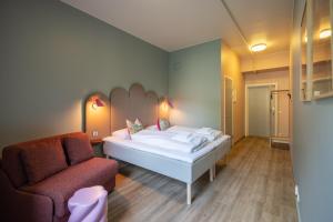 ein kleines Zimmer mit einem Bett und einem Stuhl in der Unterkunft Bunks at Rode in Oslo
