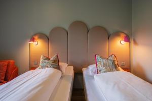 zwei Betten in einem Zimmer mit zwei Lampen an der Wand in der Unterkunft Bunks at Rode in Oslo