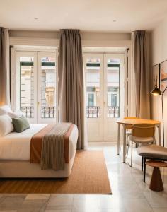 a bedroom with a bed and a table and chairs at Limehome Madrid Sol in Madrid