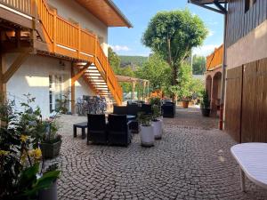 a patio with chairs and tables and plants on a brick floor at Les Cigognes de Rosheim in Rosheim