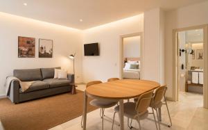 a living room with a table and a couch at Limehome Madrid Sol in Madrid