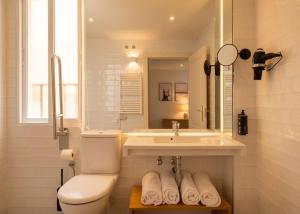 a white bathroom with a sink and a toilet at Limehome Madrid Sol in Madrid +62 photos