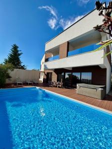 a house with a swimming pool in front of a house at Villa Estate in Novalja