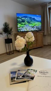 a vase with flowers on a table in a living room at Gästehaus Zoller - Rettenberg im Allgäu in Rettenberg +19 photos