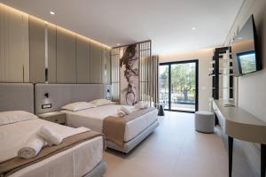a hotel room with two beds and a desk at Marea Suites Borsh in Borsh
