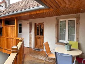 a patio with a table and chairs on a deck at Les Cigognes de Rosheim in Rosheim