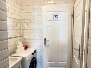 a bathroom with a white door and a washing machine at GREEN HOUSE Hostel in Krakow