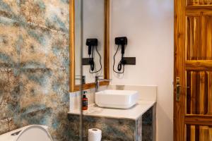 a bathroom with a sink and a toilet at African Bungalows in Nungwi
