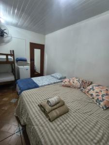 a bedroom with a bed with two towels on it at ECO BROTAS Pousada e Rafting in Brotas