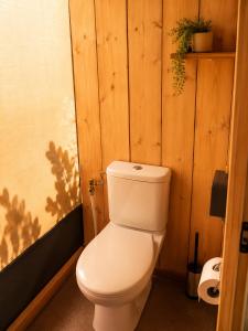 eine weiße Toilette in einem Badezimmer mit Holzwänden in der Unterkunft Anna Glamping in Fuen Negra