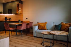 a living room with a couch and a table and chairs at Appartementhaus Absmeier in Bad Füssing