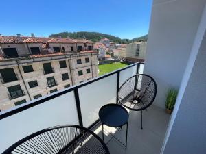 a balcony with two chairs and a view of a building at Joaquín Potel in Caldas de Reis