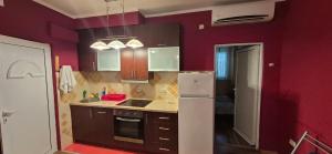 a kitchen with red walls and a white refrigerator at Old town Budva D&M in Budva