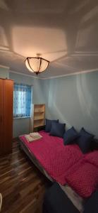 a bedroom with a bed with red sheets and black pillows at Old town Budva D&M in Budva