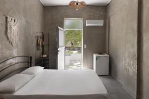 a bedroom with a bed and a door to a yard at Mazi in Sifnos in Sifnos