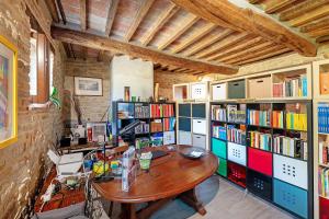 a room with a wooden table and bookshelves at Nerbone Farm Retreat in Perugia