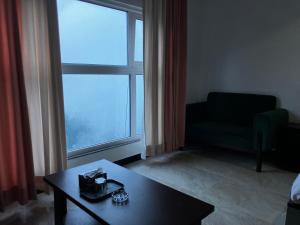 a living room with a table and a large window at Landmark Hotel & Resort in Taiwāl +58 photos